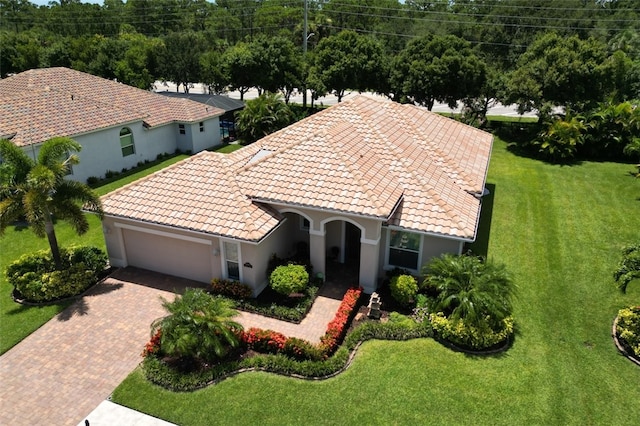 mediterranean / spanish house featuring a garage and a front yard