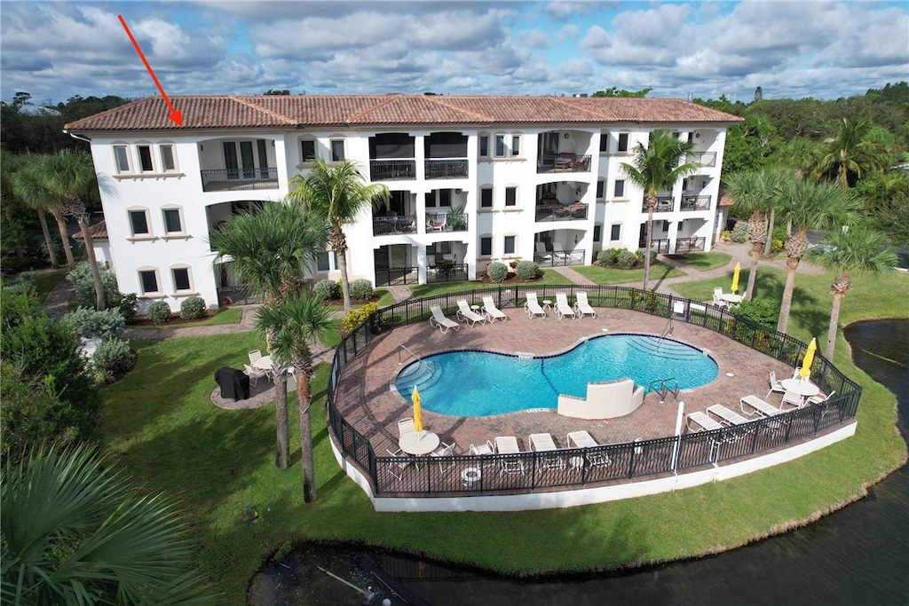 view of pool with a patio area, a yard, and a water view