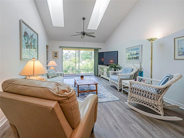 679 5th Ave, Vero Beach, FL 32962 - living area with high vaulted ceiling, baseboards, wood finished floors, and a skylight
