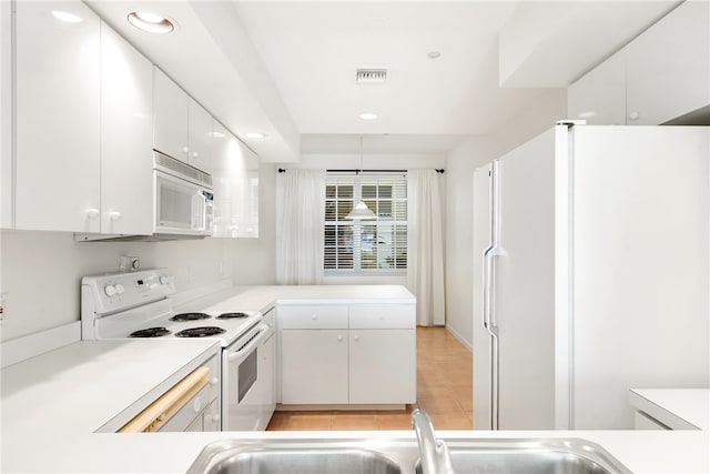 kitchen with white cabinets, white appliances, light tile patterned floors, and sink