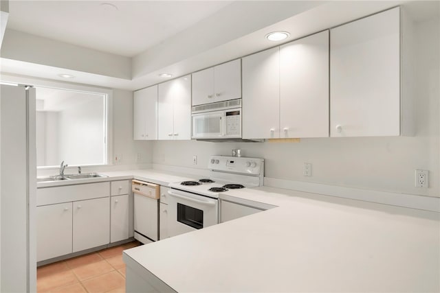 kitchen featuring kitchen peninsula, sink, light tile patterned flooring, white cabinetry, and white appliances