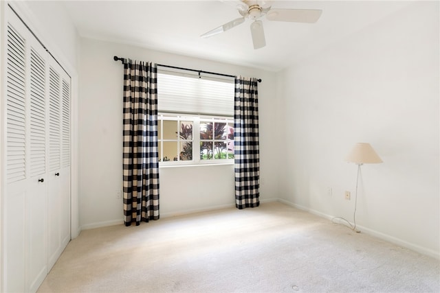 unfurnished bedroom featuring ceiling fan, a closet, and light colored carpet