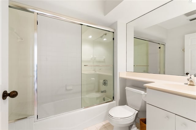 full bathroom featuring bath / shower combo with glass door, vanity, tile patterned floors, and toilet