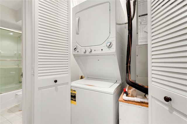 laundry area featuring light tile patterned floors and stacked washer / drying machine