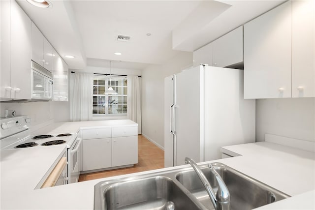 kitchen with light hardwood / wood-style floors, white cabinets, sink, a raised ceiling, and white appliances