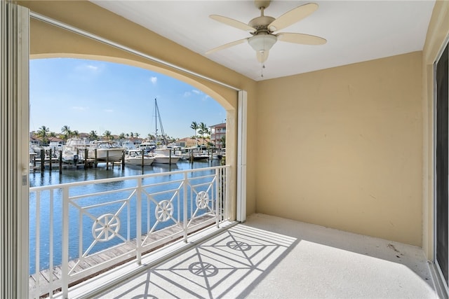 balcony with ceiling fan and a water view