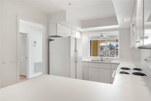 kitchen featuring white appliances, sink, ceiling fan, and white cabinets