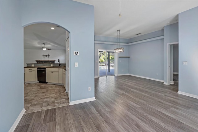 interior space with ceiling fan, dishwasher, wood-type flooring, decorative light fixtures, and decorative backsplash