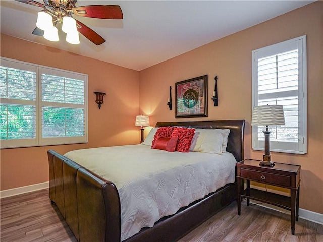 bedroom featuring a ceiling fan, baseboards, and wood finished floors