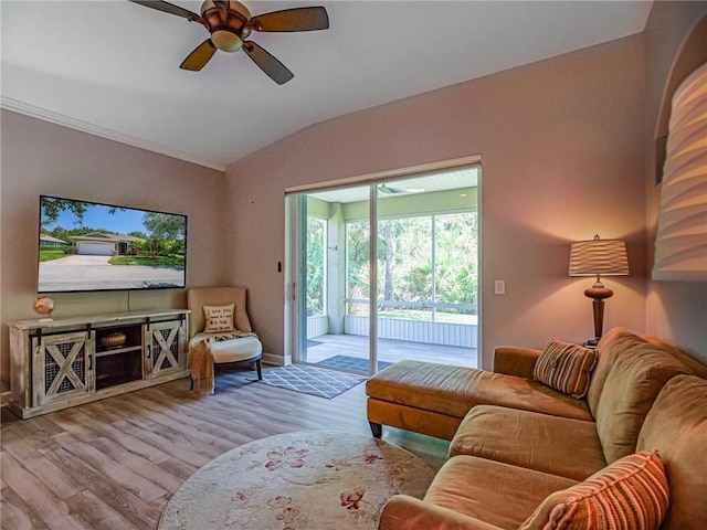 living area with ceiling fan, baseboards, vaulted ceiling, and wood finished floors