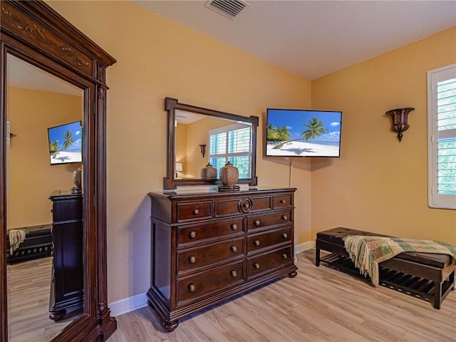 living area with baseboards, visible vents, plenty of natural light, and light wood finished floors