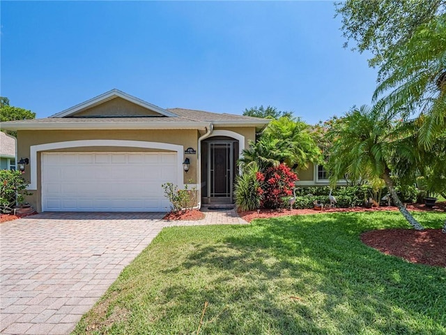 view of front of house with a garage, decorative driveway, a front lawn, and stucco siding