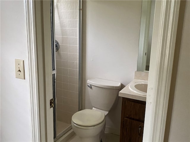 bathroom featuring a shower with shower door, vanity, and toilet