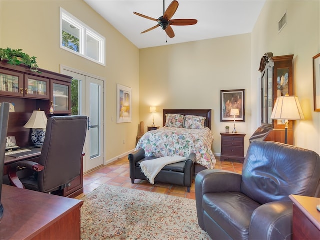 bedroom featuring ceiling fan, light tile patterned floors, a high ceiling, and multiple windows