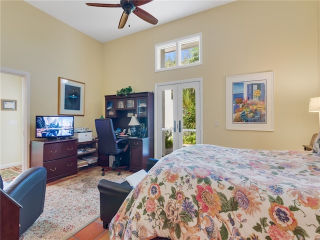 bedroom featuring ceiling fan, access to exterior, and a high ceiling