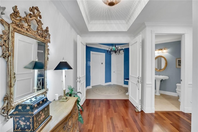 601 N Swim Club Dr Unit 3A, Vero Beach, FL 32963 - foyer featuring a chandelier, wood finished floors, crown molding, and a tray ceiling