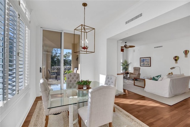 601 N Swim Club Dr Unit 3A, Vero Beach, FL 32963 - dining area featuring wood finished floors, a chandelier, and ceiling fan