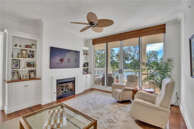 601 N Swim Club Dr Unit 3A, Vero Beach, FL 32963 - living room with healthy amount of natural light, built in shelves, a ceiling fan, wood finished floors, and crown molding
