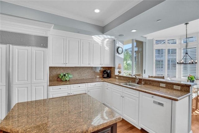601 N Swim Club Dr Unit 3A, Vero Beach, FL 32963 - kitchen with paneled built in fridge, a peninsula, white cabinetry, backsplash, and recessed lighting