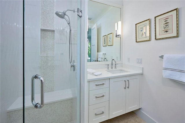 full bathroom with baseboards, a stall shower, and vanity