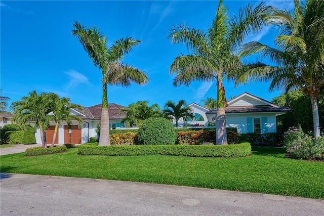 view of front of property featuring a front yard, an attached garage, and concrete driveway