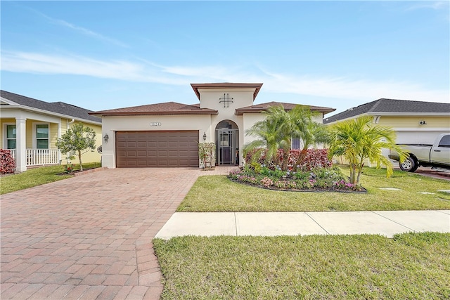 mediterranean / spanish-style house featuring a garage and a front lawn