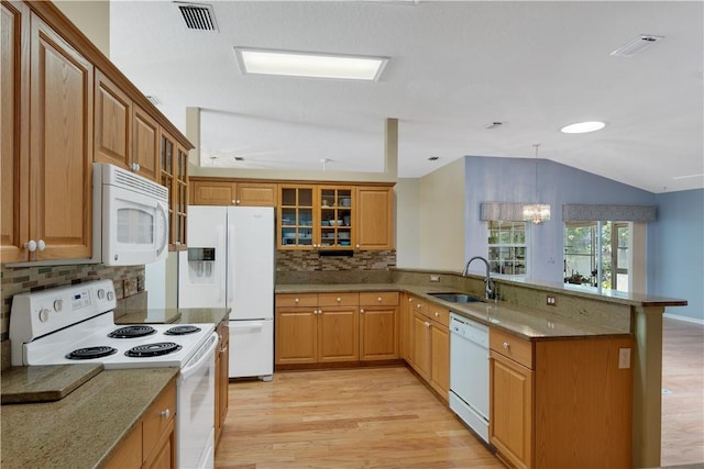 2615 15th St, Vero Beach, FL 32960 - kitchen featuring white appliances, a peninsula, light wood-style floors, decorative backsplash, and lofted ceiling