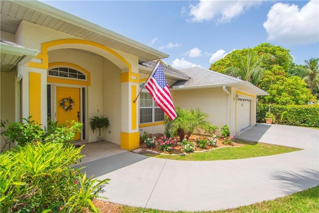 2615 15th St, Vero Beach, FL 32960 - doorway to property featuring stucco siding, a garage, and driveway