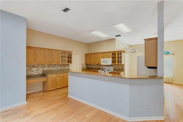 2615 15th St, Vero Beach, FL 32960 - kitchen with tasteful backsplash, white microwave, light wood-style floors, and fridge