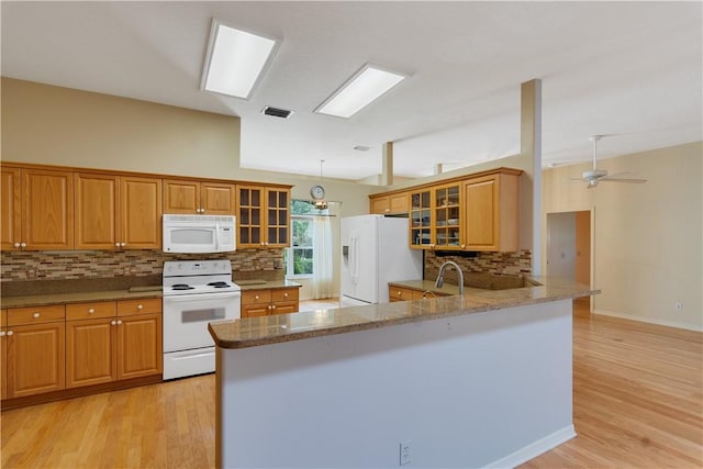 2615 15th St, Vero Beach, FL 32960 - kitchen with white appliances, decorative backsplash, brown cabinetry, and a peninsula