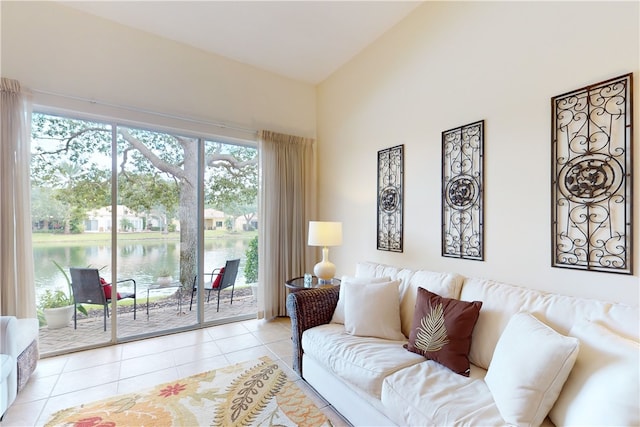 living room with lofted ceiling, a water view, light tile patterned floors, and plenty of natural light