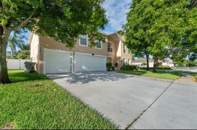 6057 Ridge Lake Cir, Vero Beach, FL 32967 - view of front of house featuring stucco siding, an attached garage, and concrete driveway