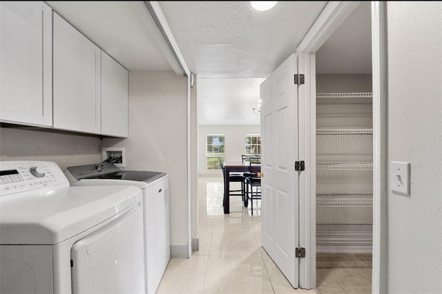 6057 Ridge Lake Cir, Vero Beach, FL 32967 - washroom with cabinet space, washer and dryer, light tile patterned floors, and a textured ceiling