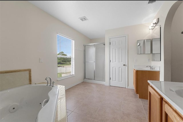 6057 Ridge Lake Cir, Vero Beach, FL 32967 - bathroom with two vanities, a shower stall, a whirlpool tub, and tile patterned floors