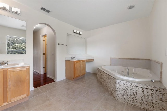 6057 Ridge Lake Cir, Vero Beach, FL 32967 - full bathroom featuring two vanities, a garden tub, and tile patterned flooring
