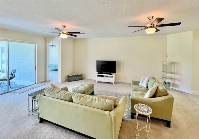 carpeted living room featuring ceiling fan and a textured ceiling