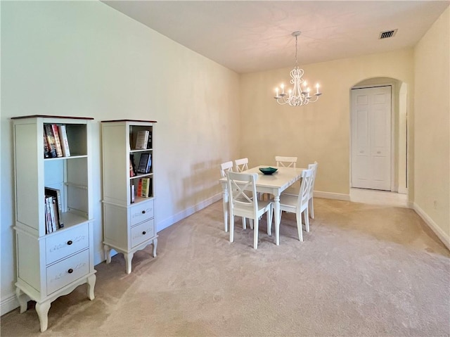 carpeted dining space featuring a notable chandelier