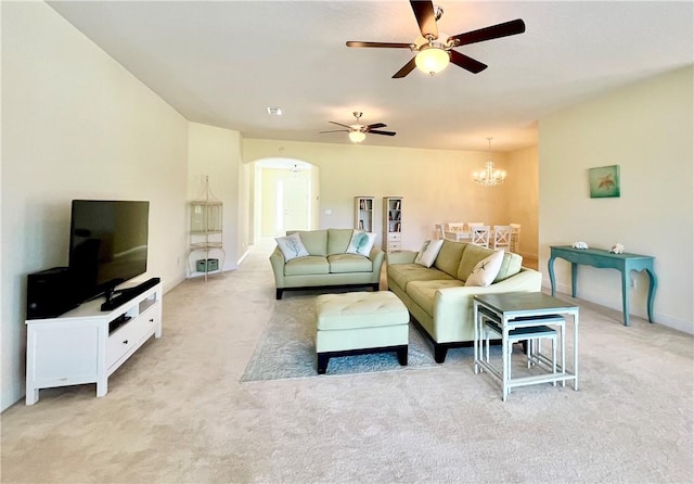 living room with ceiling fan with notable chandelier and light colored carpet