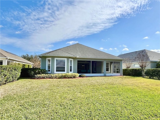 rear view of property with a sunroom and a lawn