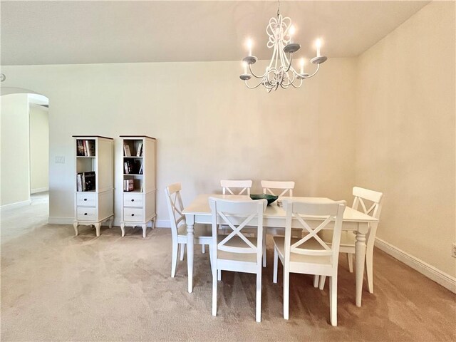 dining room with carpet flooring and a chandelier