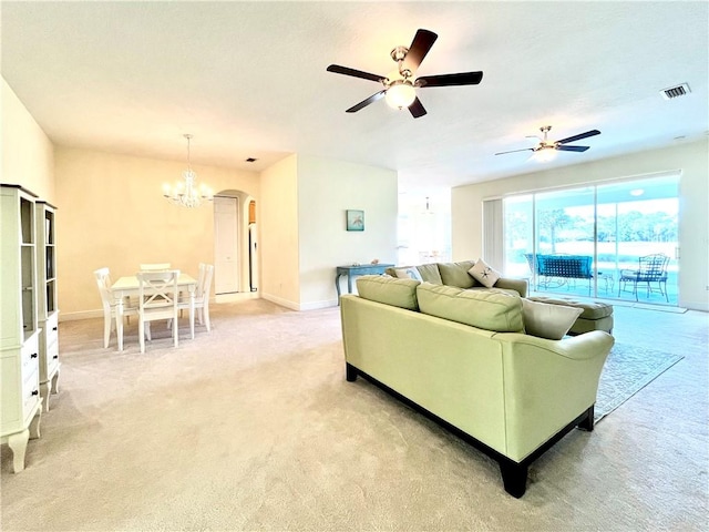 living room with light carpet and ceiling fan with notable chandelier