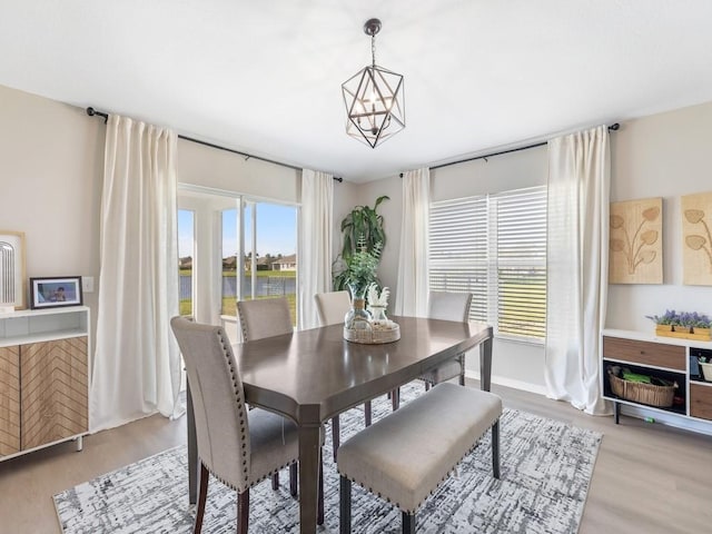 dining area featuring a chandelier, baseboards, and light wood-style flooring