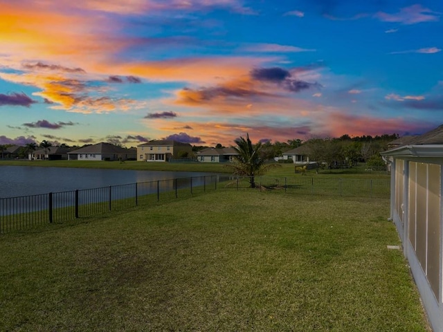 view of yard featuring a residential view, fence private yard, and a water view