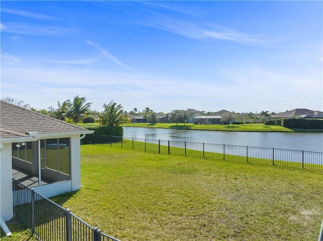 view of yard with a water view, a sunroom, and fence