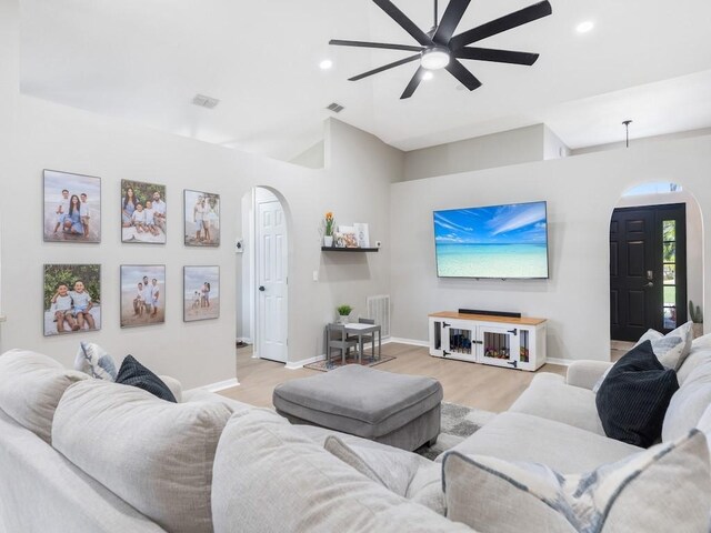 living room with recessed lighting, arched walkways, baseboards, and ceiling fan