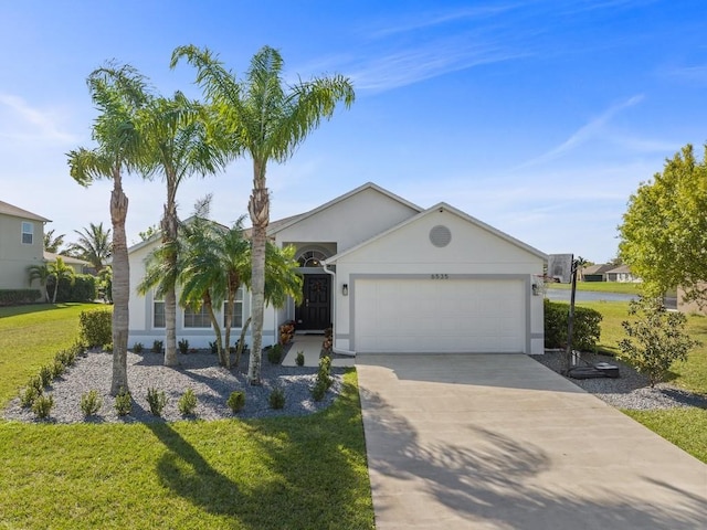 view of front of property with stucco siding, an attached garage, concrete driveway, and a front yard