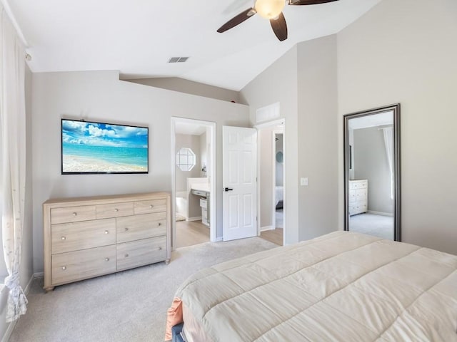 bedroom featuring visible vents, light colored carpet, connected bathroom, and vaulted ceiling