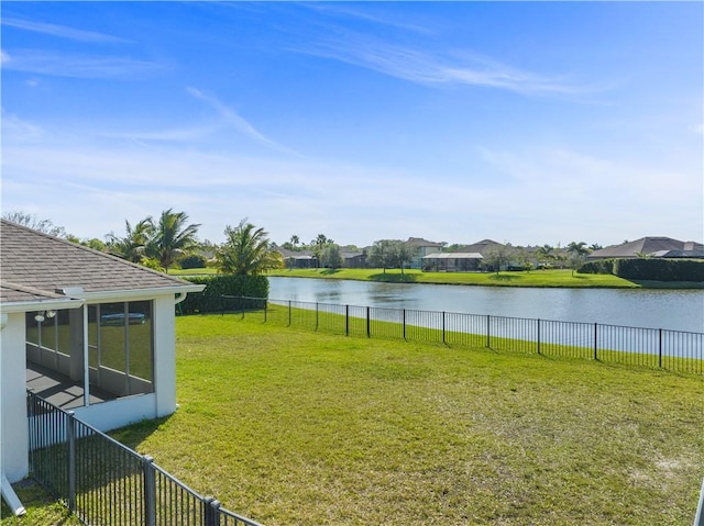 view of yard featuring fence, a water view, and a sunroom