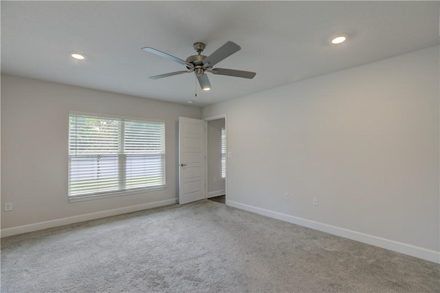 carpeted spare room with recessed lighting, ceiling fan, and baseboards