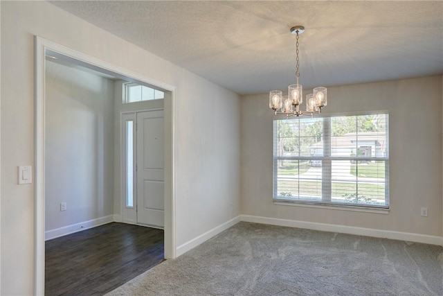 interior space with baseboards, a textured ceiling, and an inviting chandelier